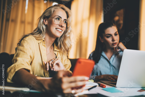 Satisfied youthful female coworkers working on business start up at home