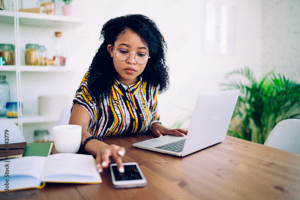 Thoughtful woman using smartphone and laptop at home - obrazy, fototapety, plakaty 