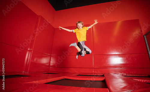 Little girl jumping on trampoline in fly park photo