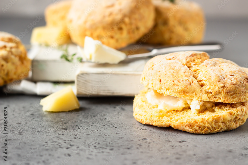 Wooden cutting board with delicious English scones with cheese. Perfect breakfast or lunch. Grey stone background.