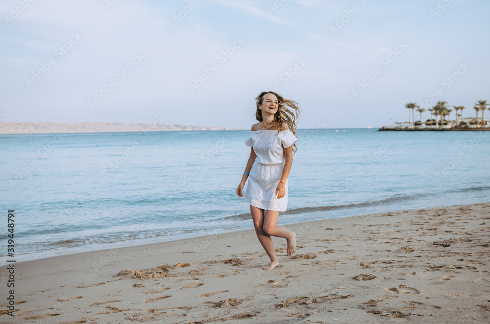 Happy woman enjoying beach running joyful in summer by tropical blue water Happy woman enjoying beach running joyful in summer by tropical blue water