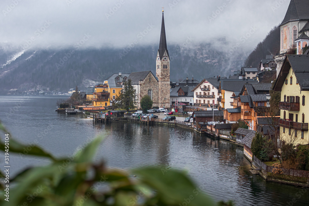 Classic panoramic view of famous old town Hallstatt and alpine deep blue lake in scenic cloudy day light on a in winter, Salzkammergut, Austria