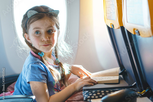 curious girl with book at airplane
