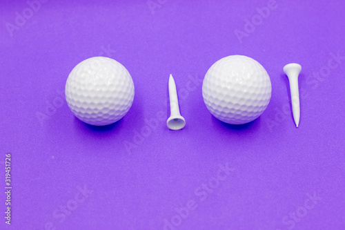 Golf ball and tees are on purple background
