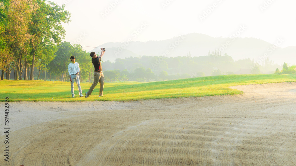 Obraz premium Golfers exploding sand in the bunker.