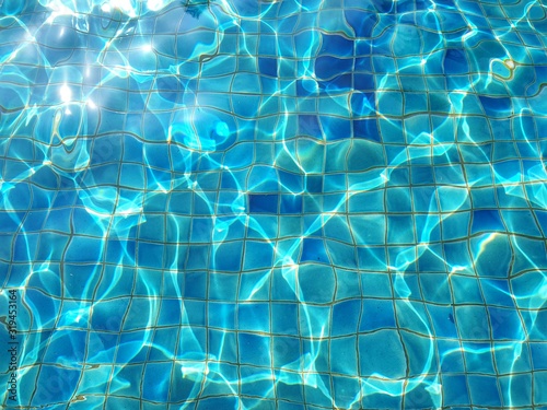 Surface of Water in swimming pool with sun reflection