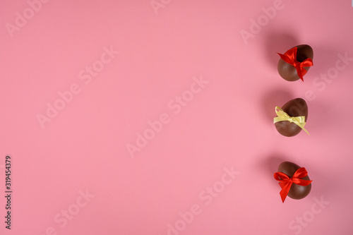 Chocolate eggs on the pink background. Copy space. photo