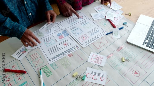 Web designer working laptop responsive design. Creative UI Ux designer teamwork meeting planning designing wireframe layout application development for smartphone screen mobile phone technology