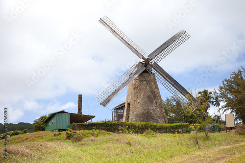 View of an old mill against a blue sky of clouds on a clear Sunny day, Barbados island. Architecture, world tourism, landscape, architecture.