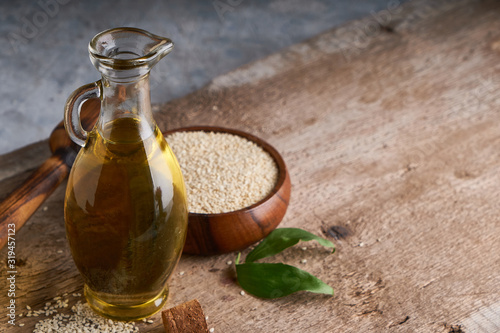 Healthy Sesame oil in glass bottle and sesame seeds on wooden background Copy space Rustic
