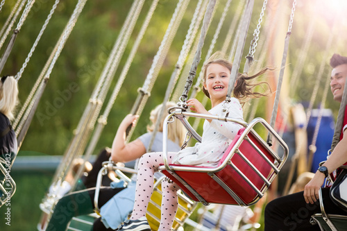 Schilderij op canvas Little girl having fun on chain carousel