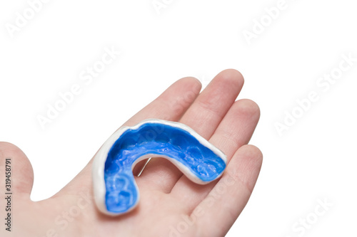 Hand with white sport mouthguard photo