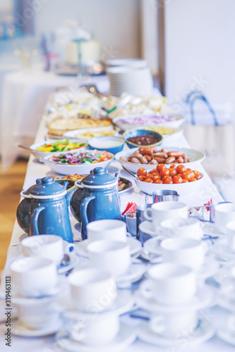 Food laid out on a white buffet table for a party
