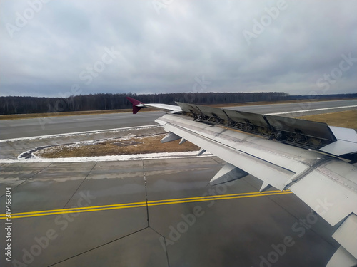 View of an plane wing with brakes on during landing