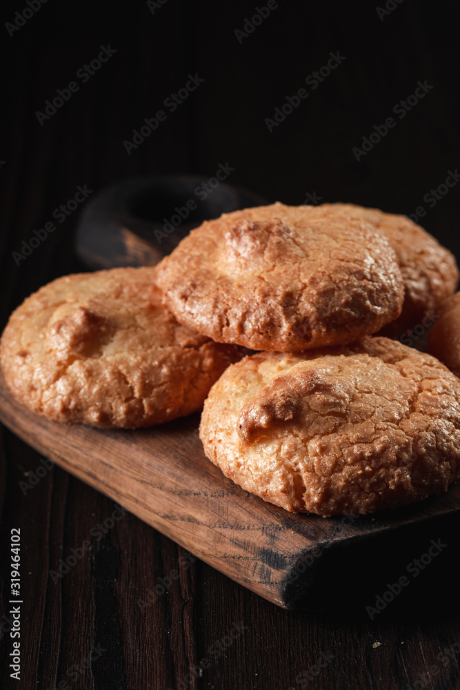 Closeup of almond cookies with golden crust on dark background