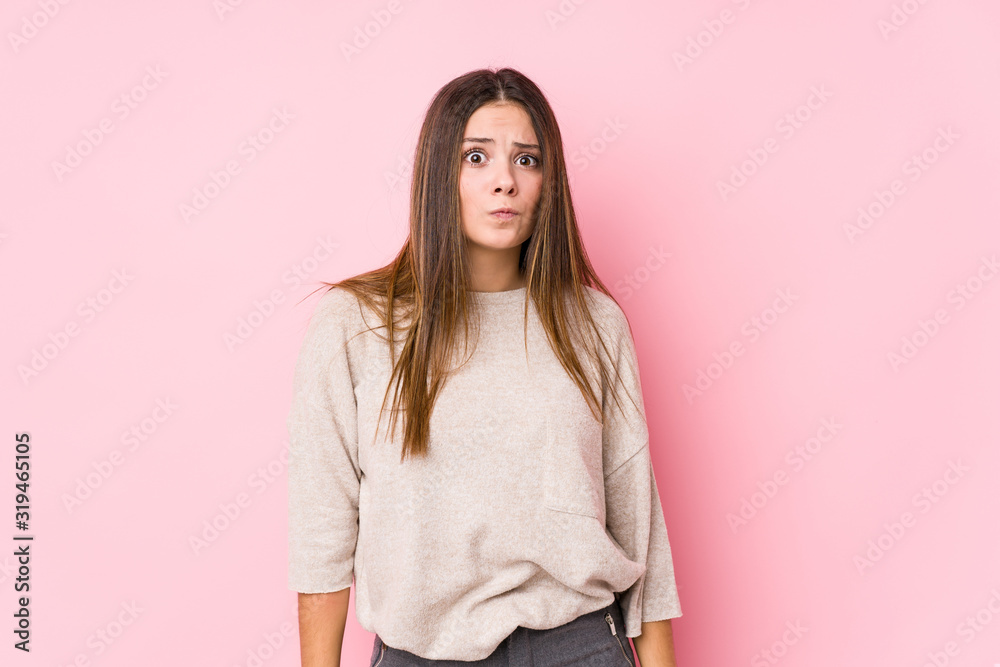 Young caucasian woman posing isolated shrugs shoulders and open eyes confused. Young caucasian woman posing isolated shrugs shoulders and open eyes confused.