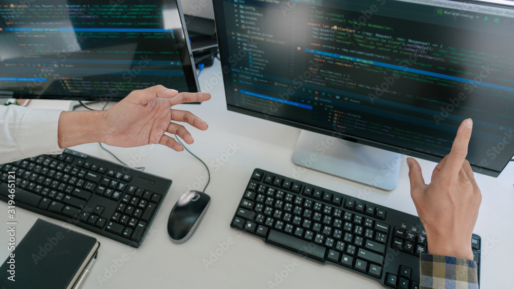 Young startup Programmers Sitting At Desks Working On Computers screen for Developing programming and coding to find solution to problem on New Application. Young startup Programmers Sitting At Desks Working On Computers screen for Developing programming and coding to find solution to problem on New Application.