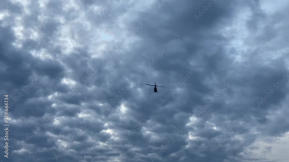 Helicopter flying over the sea. View from the ground Helicopter flying over the sea. View from the ground