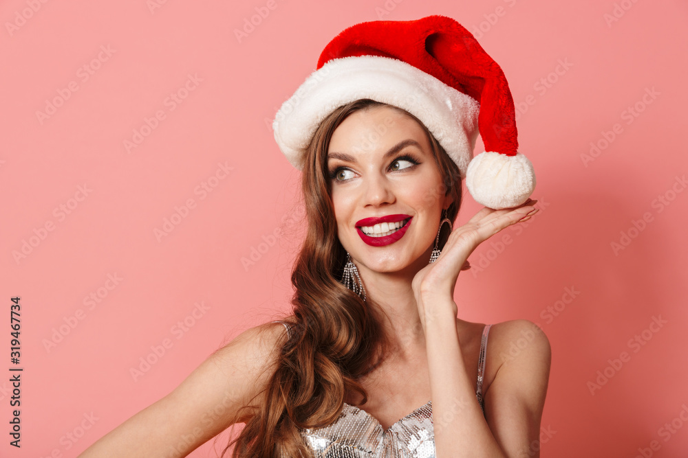 Happy positive woman in bright sequins dress wearing christmas hat. Happy positive woman in bright sequins dress wearing christmas hat.