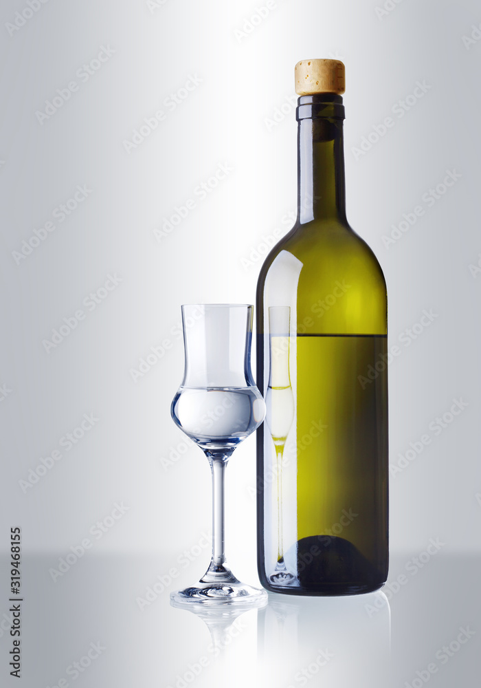 ein Glas und eine Flasche mit Grappa ein Glas und eine Flasche mit Grappa