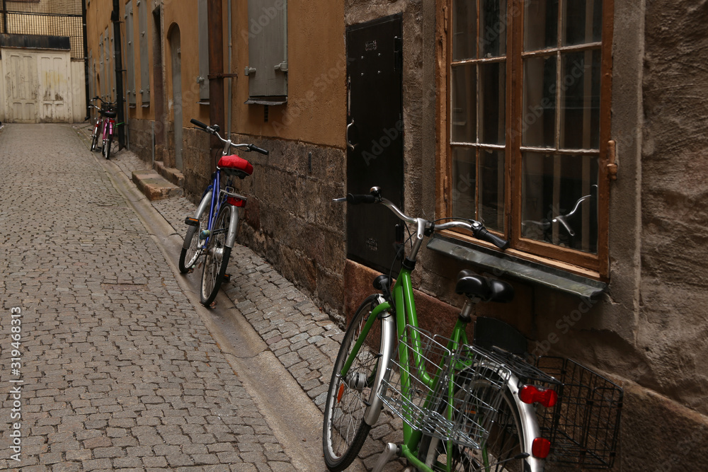 Parked bikes along house facade in old town of Stockholm, Sweden