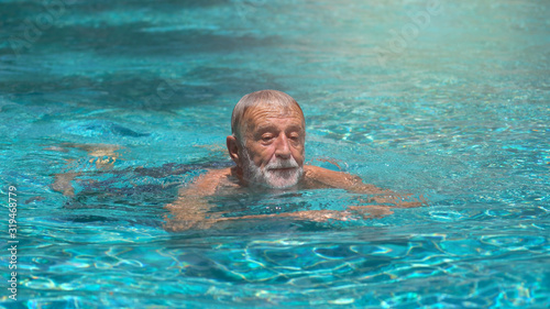 Senior man swimming in  swimming pool