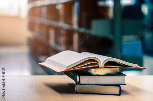 Open book on stack of books in library at school, university, college. © Charnchai saeheng