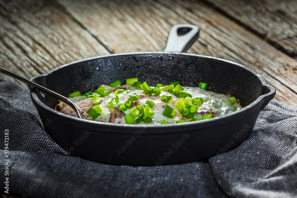 Fried eggs with ham on an old wooden background. Fried eggs with ham on an old wooden background.