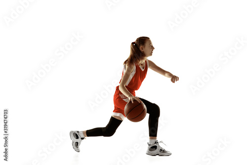 Young caucasian female basketball player in action, motion in run isolated on white background. Redhair sportive girl. Concept of sport, movement, energy and dynamic, healthy lifestyle. Training. © master1305