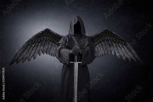 Dark angel with medieval sword in the dark