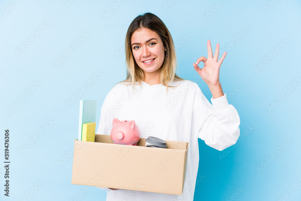 Young caucasian woman moving home isolated cheerful and confident showing ok gesture. Young caucasian woman moving home isolated cheerful and confident showing ok gesture.