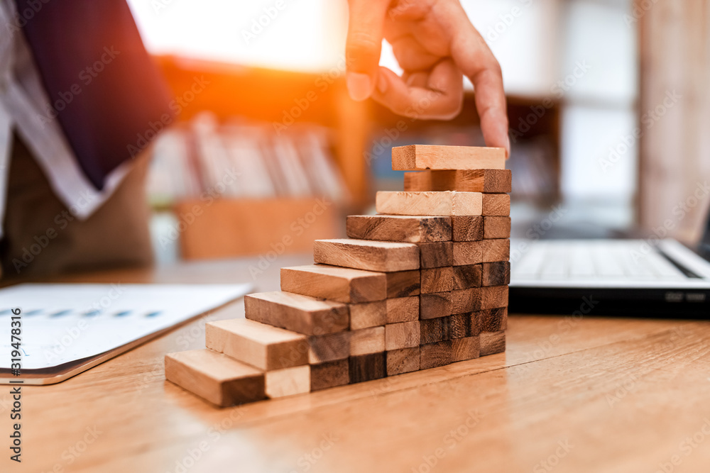 Ant eye view Male hand stacking wooden blocks. Business development and growth concept Ant eye view Male hand stacking wooden blocks. Business development and growth concept