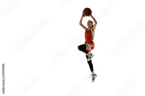 Young caucasian female basketball player in action, motion in jump isolated on white background. Redhair sportive girl. Concept of sport, movement, energy and dynamic, healthy lifestyle. Training.