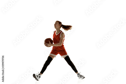 Young caucasian female basketball player in action, motion in run isolated on white background. Redhair sportive girl. Concept of sport, movement, energy and dynamic, healthy lifestyle. Training.