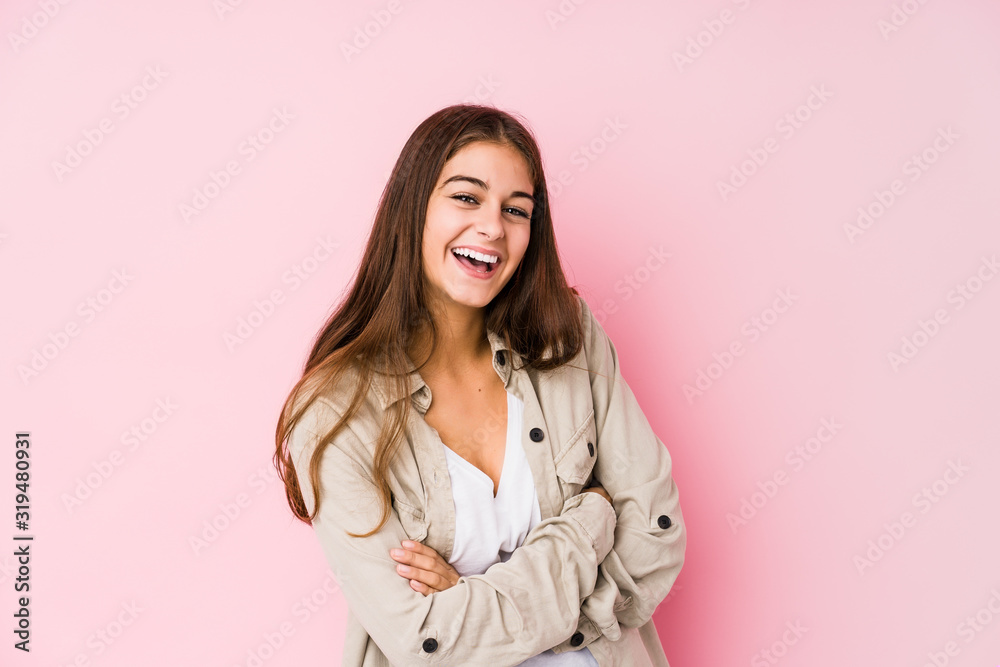 Young caucasian woman posing in a pink background laughing and having fun. Young caucasian woman posing in a pink background laughing and having fun.