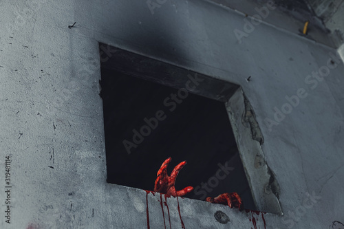 horror scence of woman with scary hand at abandoned house. hand through the hole wall. Halloween concept