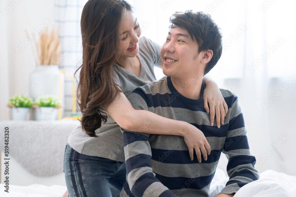 Young Asian lovers live together in the bedroom, The girl hugged the child from the back. Young Asian lovers live together in the bedroom, The girl hugged the child from the back.