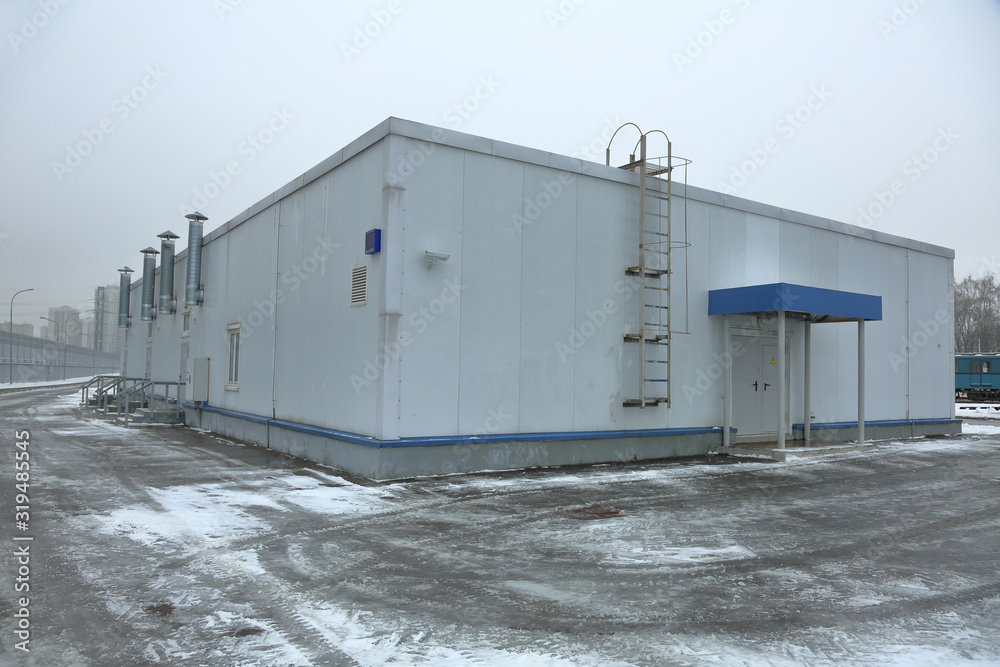 Gray industrial outbuilding of economic purpose on the factory site on a clouded day Gray industrial outbuilding of economic purpose on the factory site on a clouded day
