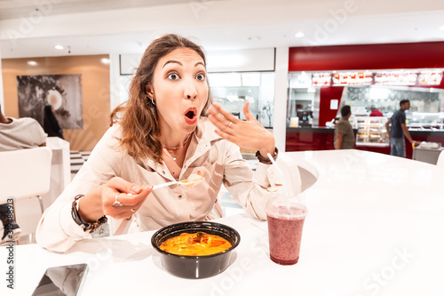 Wallpaper Mural A woman eating too hot and peppery soup in an Asian fast food restaurant
