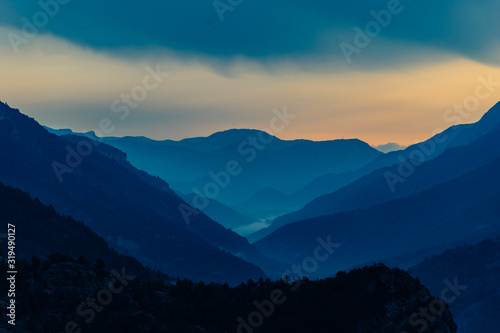 Fototapeta Naklejka Na Ścianę i Meble -  The foggy Alps mountains during the sunrise