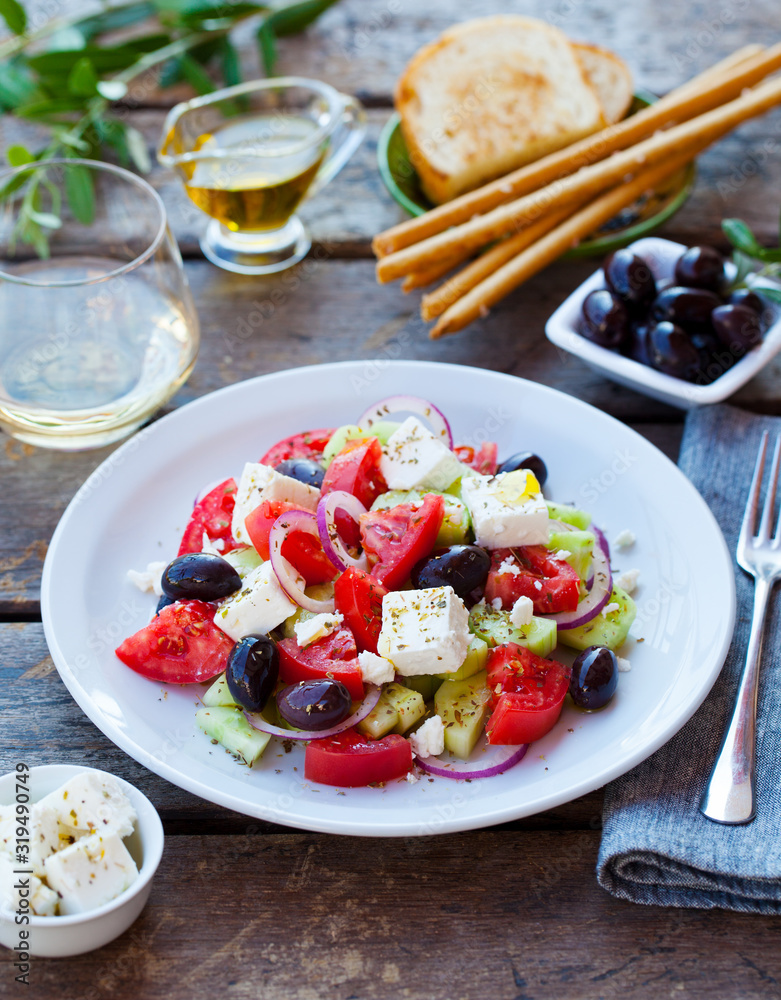 Greek salad. Fresh vegetables, feta cheese and black olives with white wine.