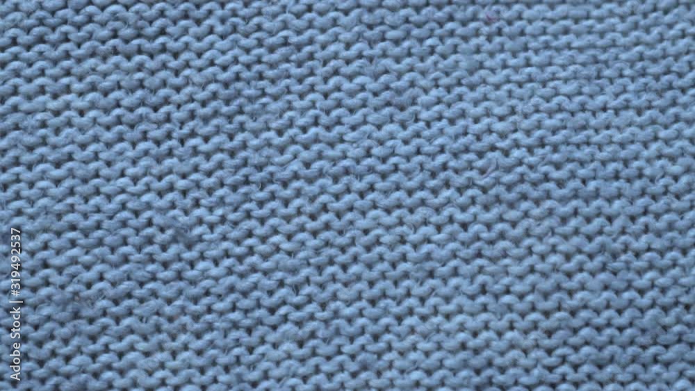 Close-up of blue knitted wool fabric texture, camera slide. Close-up of blue knitted wool fabric texture, camera slide.