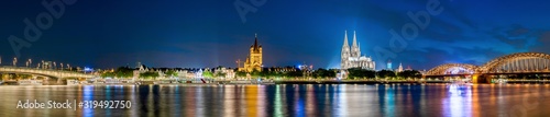 Panorama of the Cologne skyline at night with illuminated Cologne Cathedral  old town  Rhine and bridges