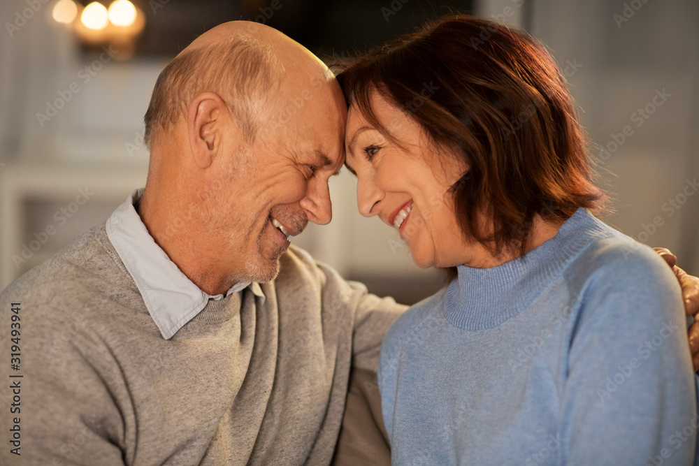 relationships, old age and people concept - happy smiling senior couple at home in evening relationships, old age and people concept - happy smiling senior couple at home in evening
