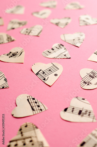 Paper hearts with music notes on pink paper background