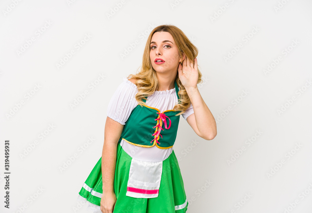 Young woman wearing a saint patricks day clothes isolated trying to listening a gossip. Young woman wearing a saint patricks day clothes isolated trying to listening a gossip.