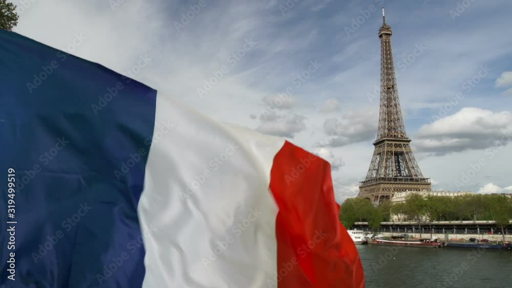Eiffel Tower, Paris with French Flag waving in France. Close up