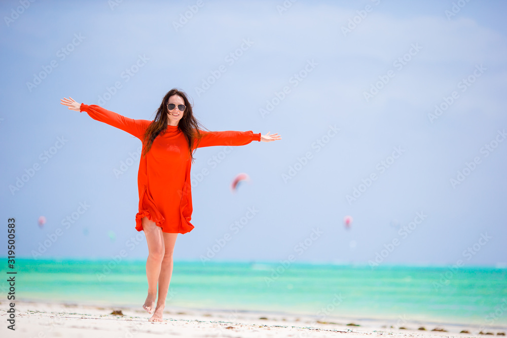 Young beautiful woman having fun on tropical seashore. Happy girl background the blue sky and turquoise water in the sea on caribbean island Young beautiful woman having fun on tropical seashore. Happy girl background the blue sky and turquoise water in the sea on caribbean island