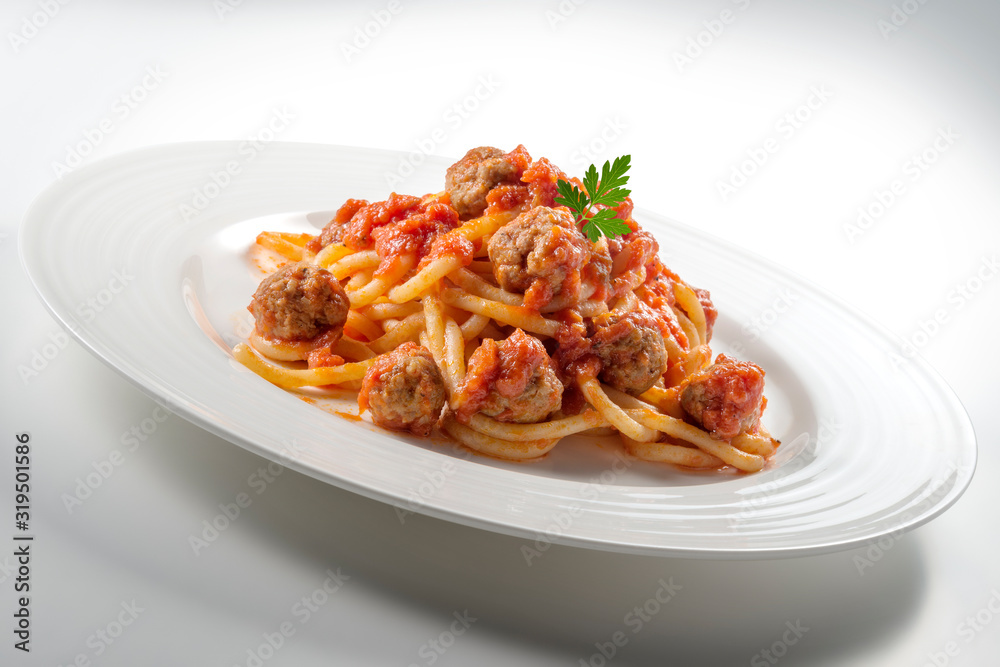 Plate of spaghetti with tomato and meatballs with parsley leaves Plate of spaghetti with tomato and meatballs with parsley leaves
