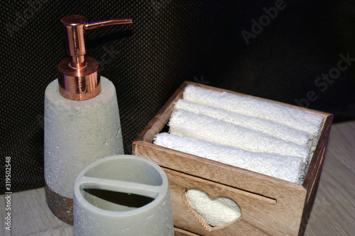 Bathroom accessories on a brown background. Soap and a white towel for hygiene.